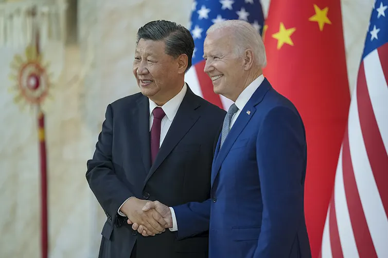 El presidente Biden y el presidente chino Xi Jinping se dan la mano.