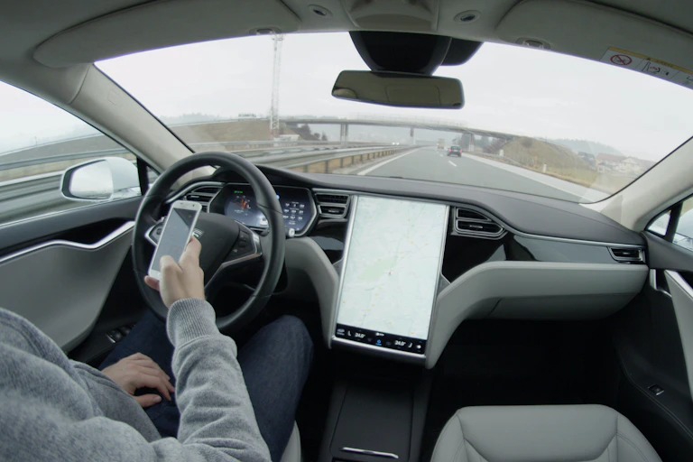 Conductor en un vehículo con el sistema de piloto automático.