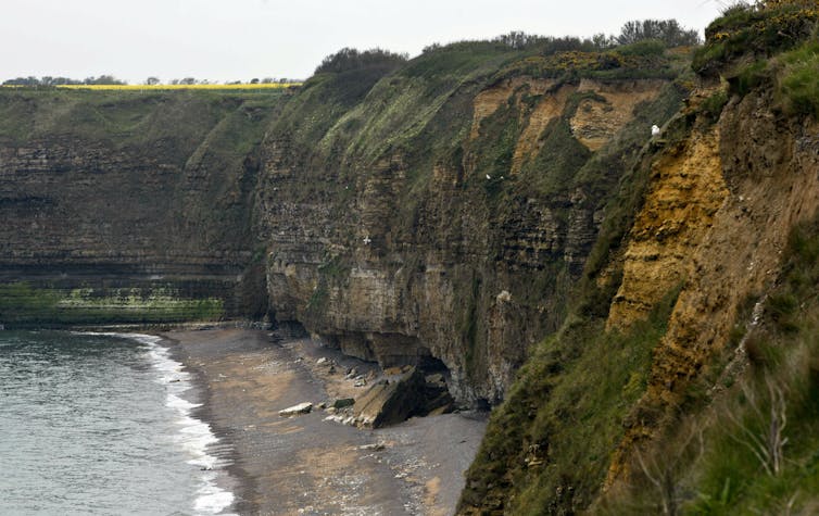 Sheer cliffs climb from a narrow beach.
