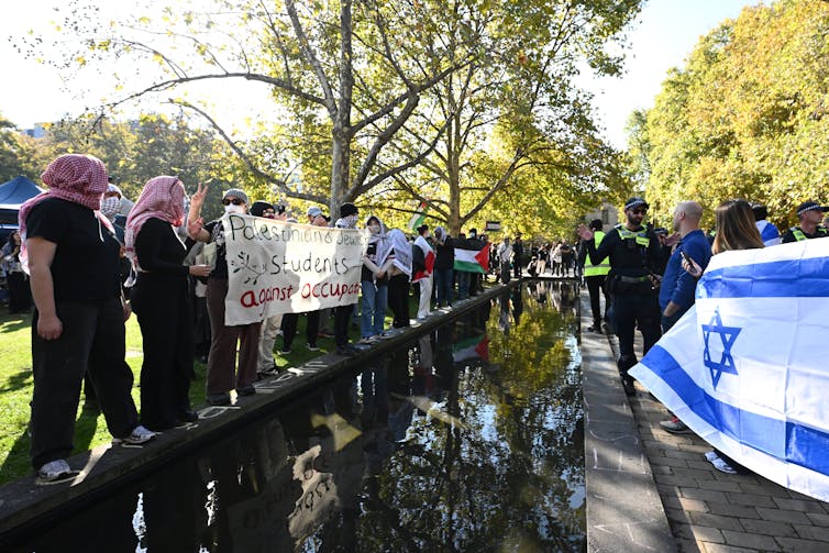Pro-Israel demonstrators gather opposite a Pro-Palestine encampment.