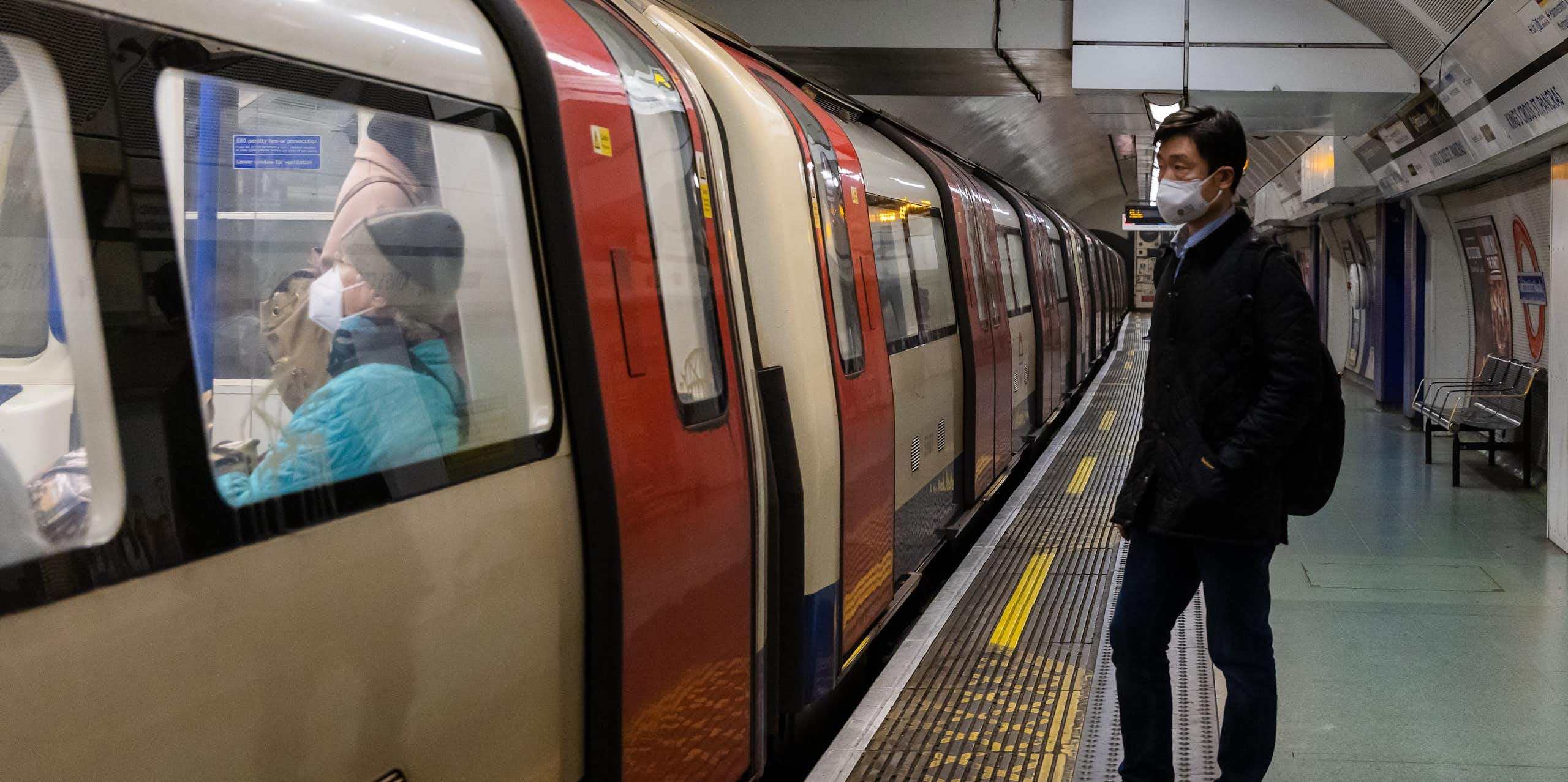 Man wearing a mask, standing on London Underground platform