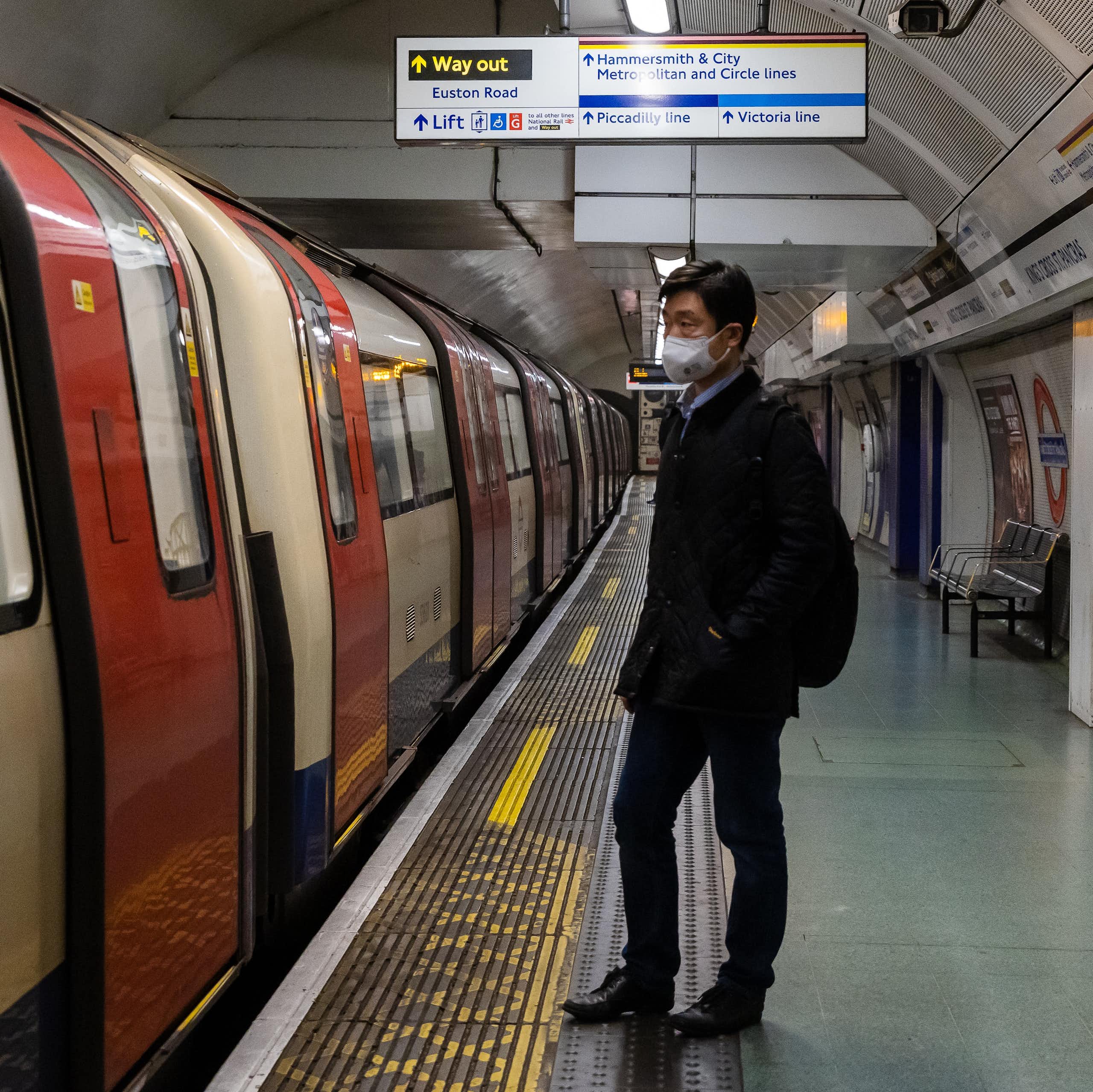 Man wearing a mask, standing on London Underground platform
