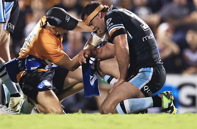 Dale Finucane of the Sharks is treated during a 2024 NRL match
