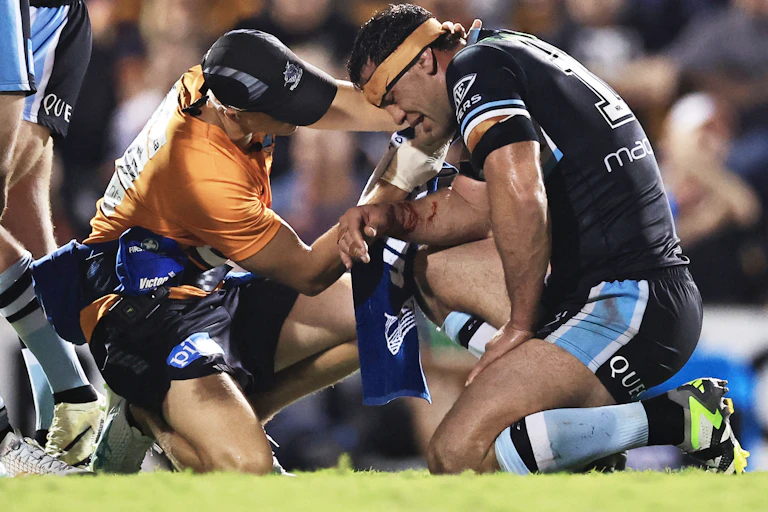Dale Finucane of the Sharks is treated during a 2024 NRL match