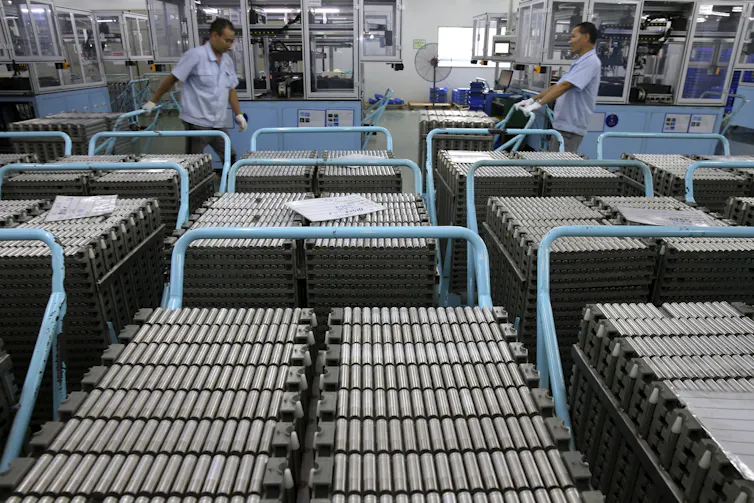 Workers moving Lithium-ion batteries in a factory in China