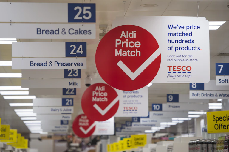 Aldi price match signs inside a Tesco store