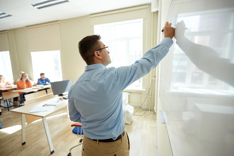 Teacher writing on whiteboard