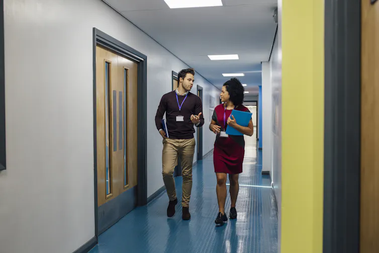 Two teachers walking in corridor