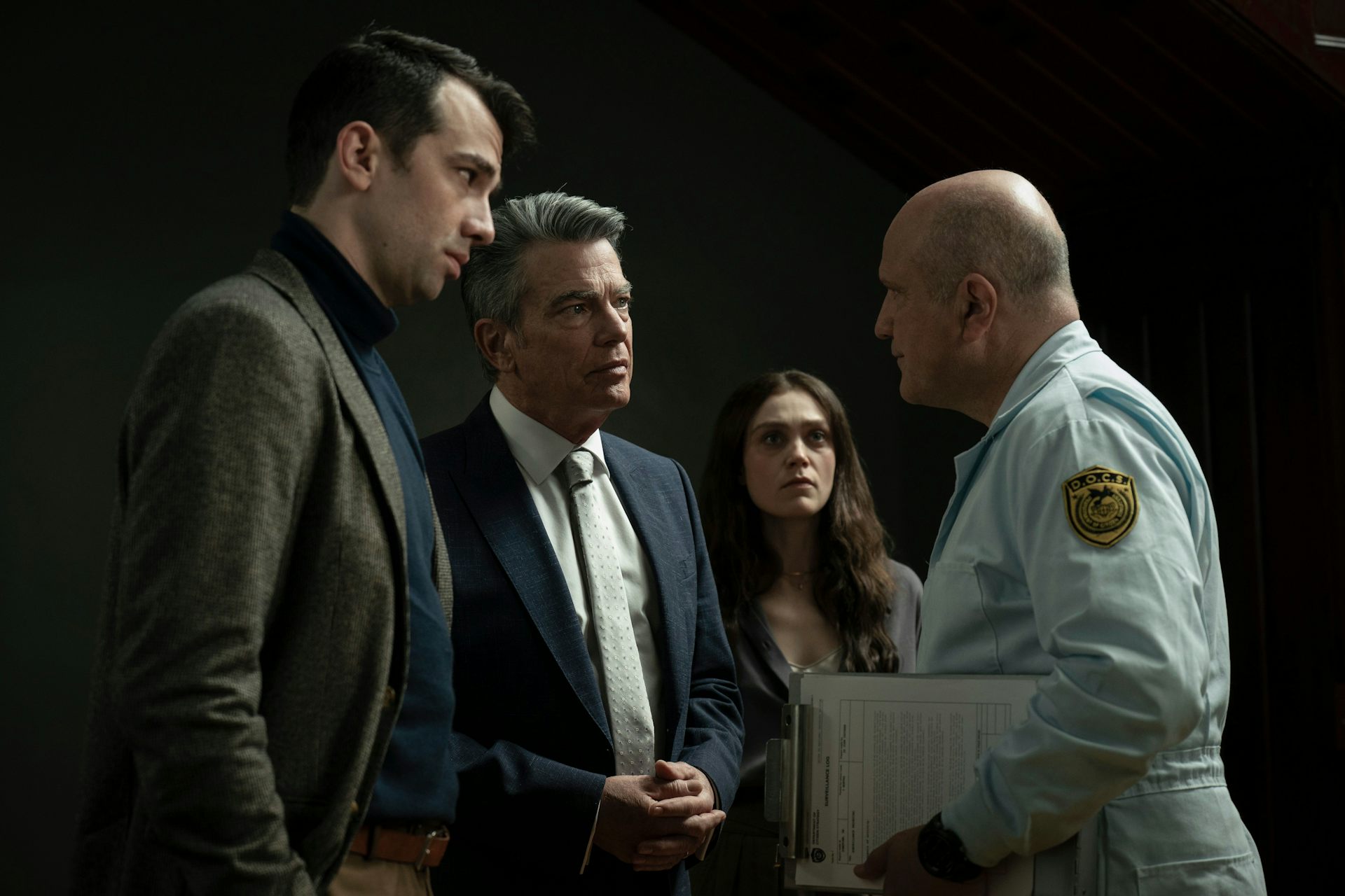 Three people seen in an intense exchange of staring while one looks on.