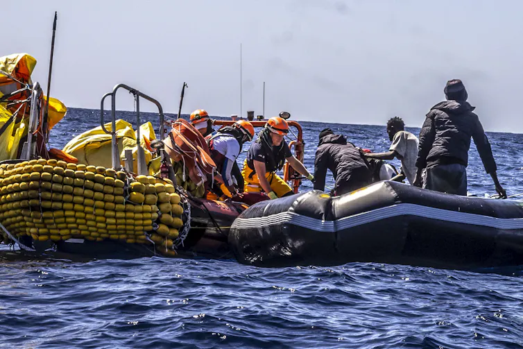 Des gens à bord d’un pneumatique sont secourus en mer