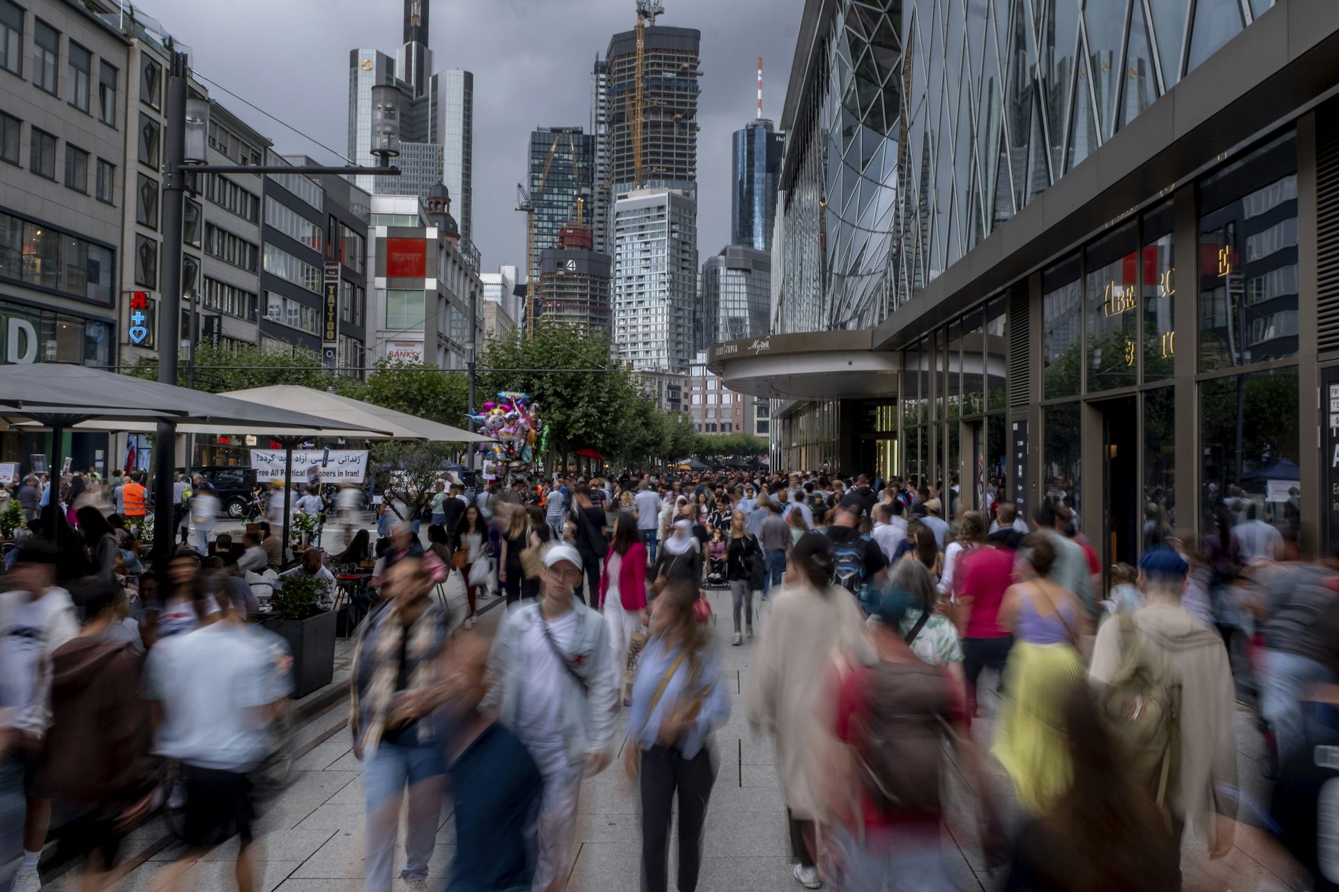 Une foule déambulent sur une artère commerciale