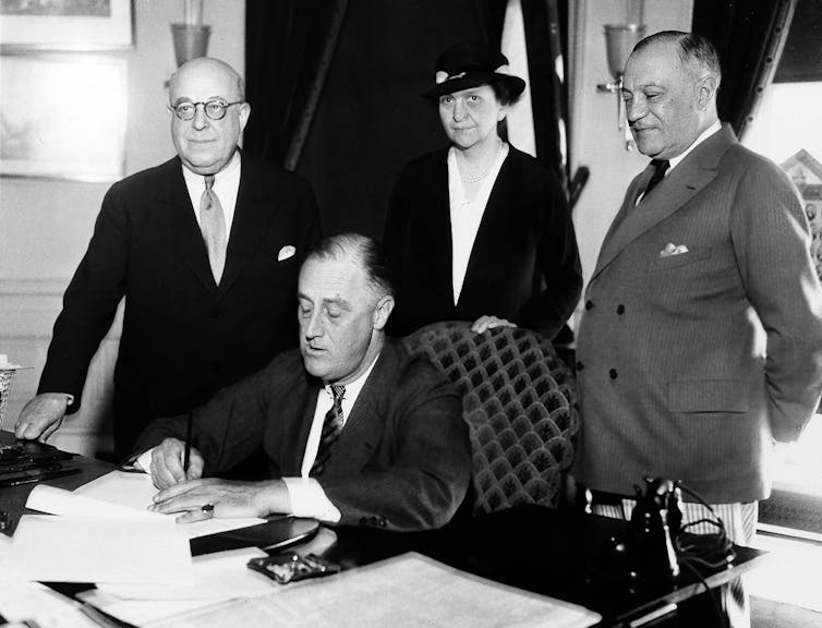 President Franklin D. Roosevelt signs a law.