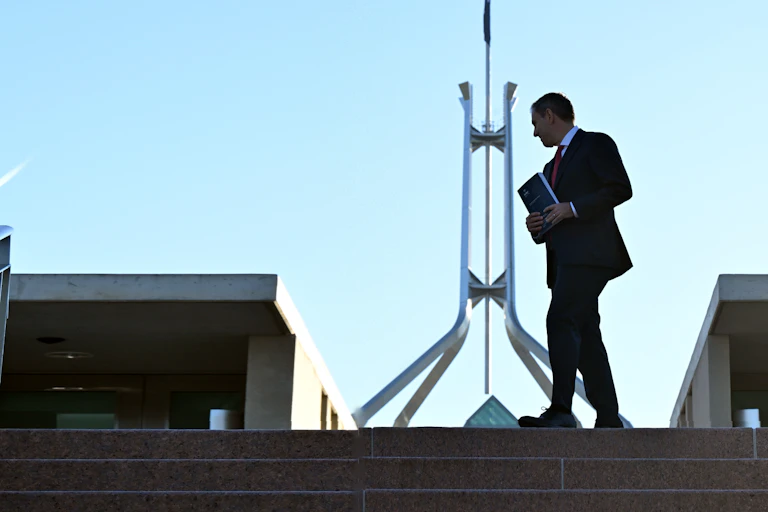 Photo of Treasurer Jim Chalmers with budget documents