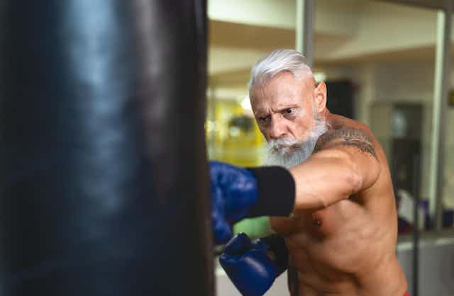 Older man punching a heavy bag