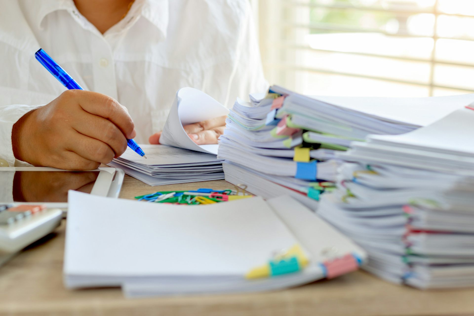 Enseignant qui relit et annote des copies