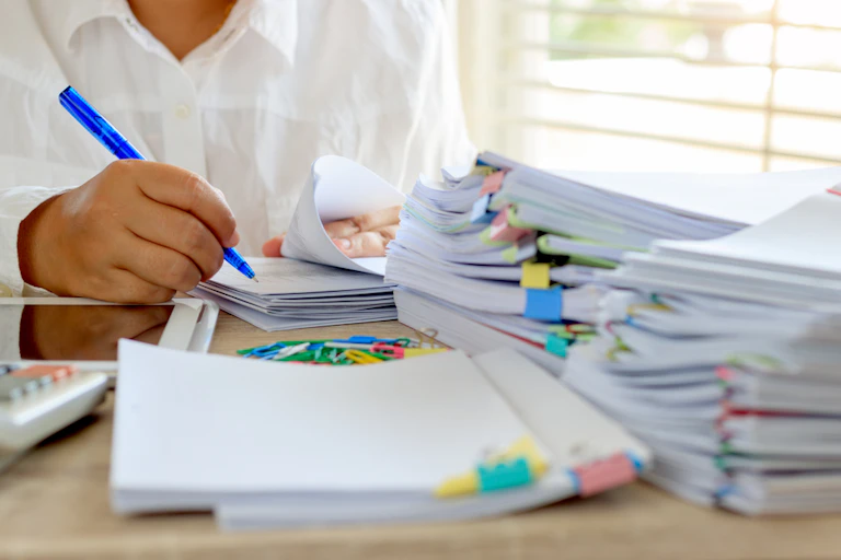 Enseignant qui relit et annote des copies