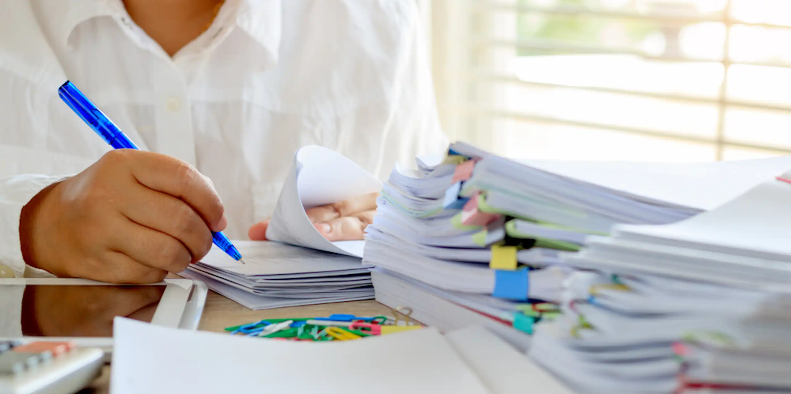 Enseignant qui relit et annote des copies