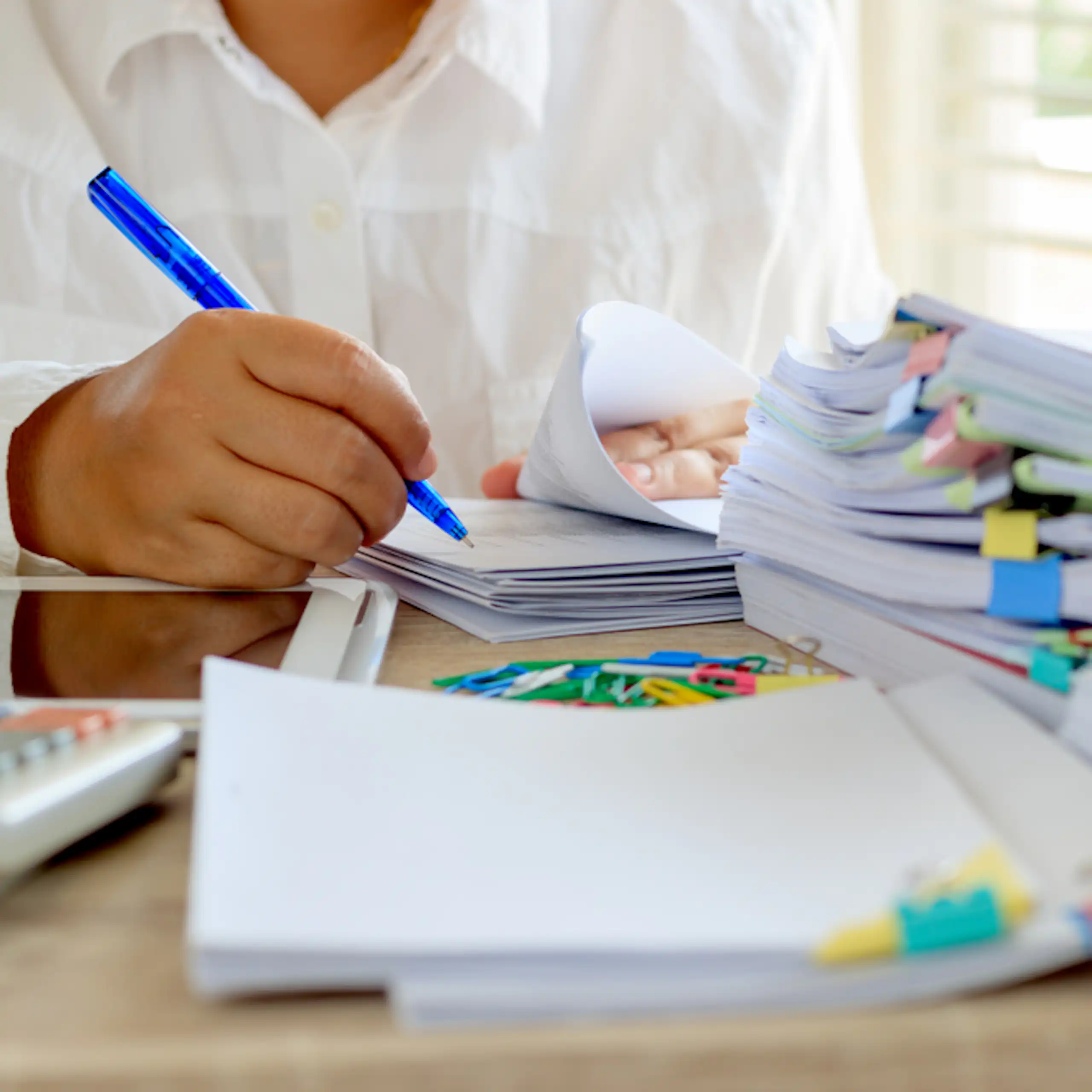 Enseignant qui relit et annote des copies