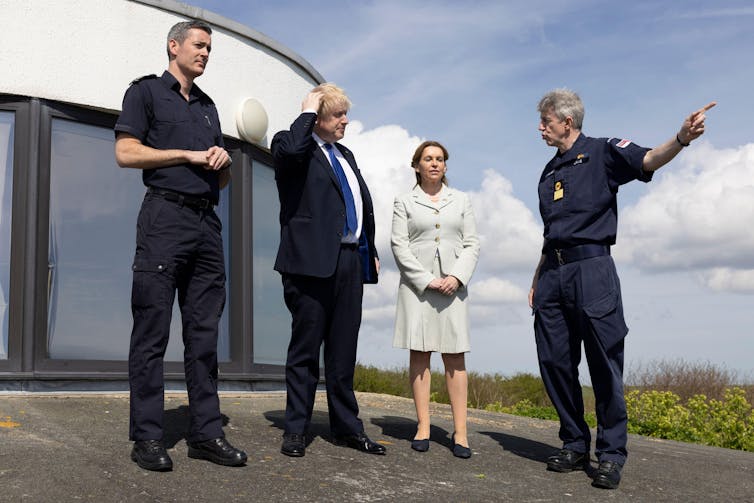 Boris Johnson e Natalie Elphicke ao lado de dois agentes de fiscalização da fronteira.