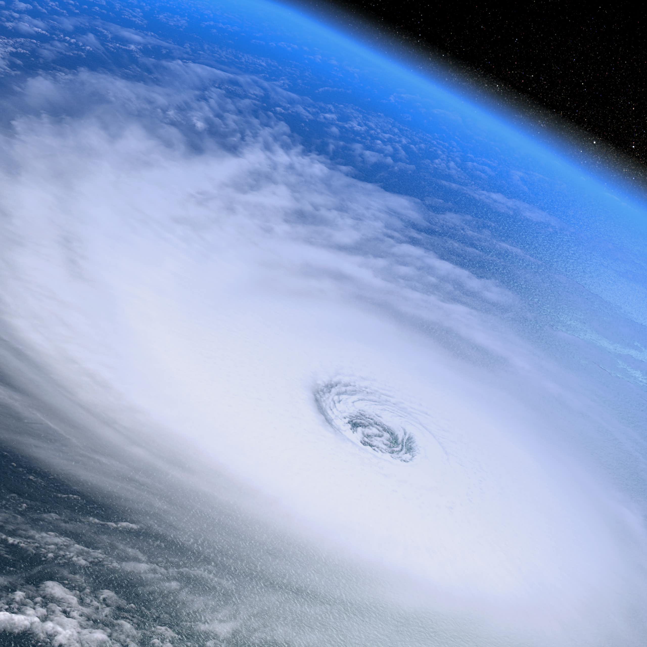 space shot looking down over white hurricane swirls over Earth