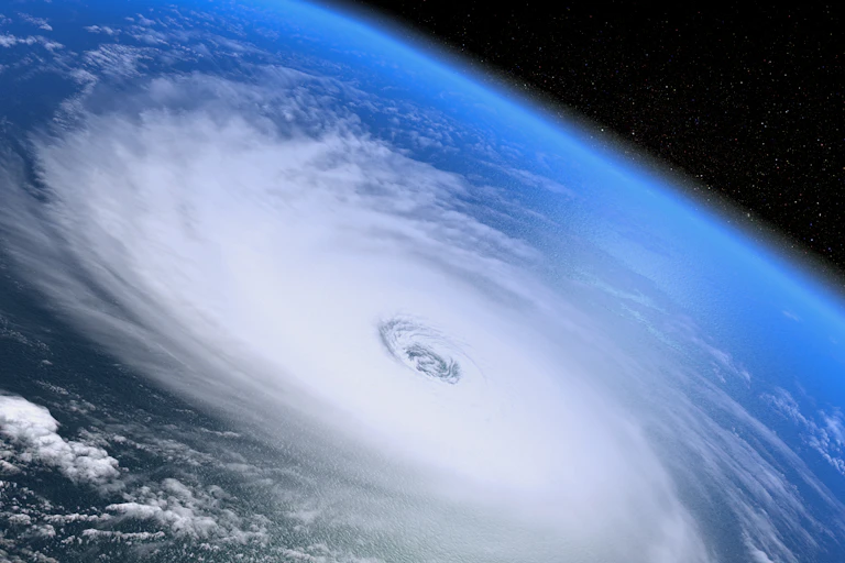 space shot looking down over white hurricane swirls over Earth