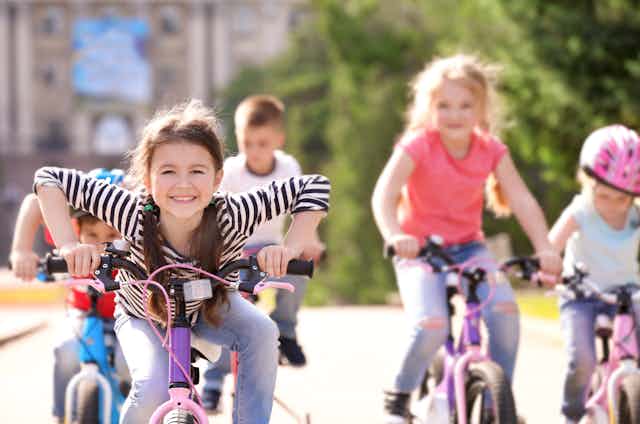 A group of children riding bicycles down a path