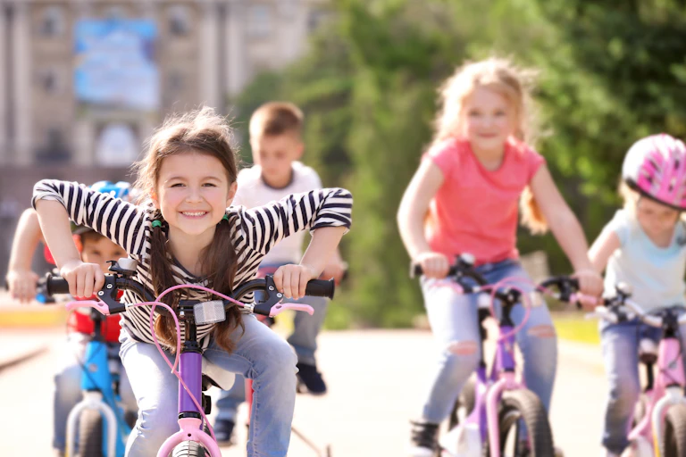 A group of children riding bicycles down a path
