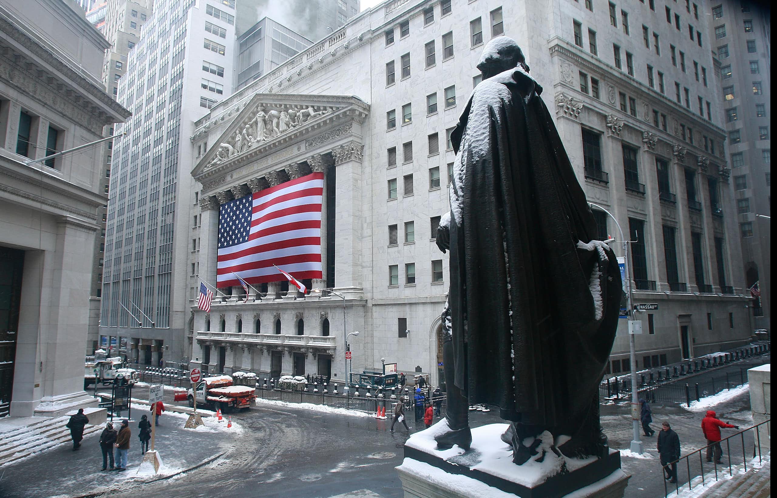 View of Wall Street and the New York Stock Exchange across a snowy street.