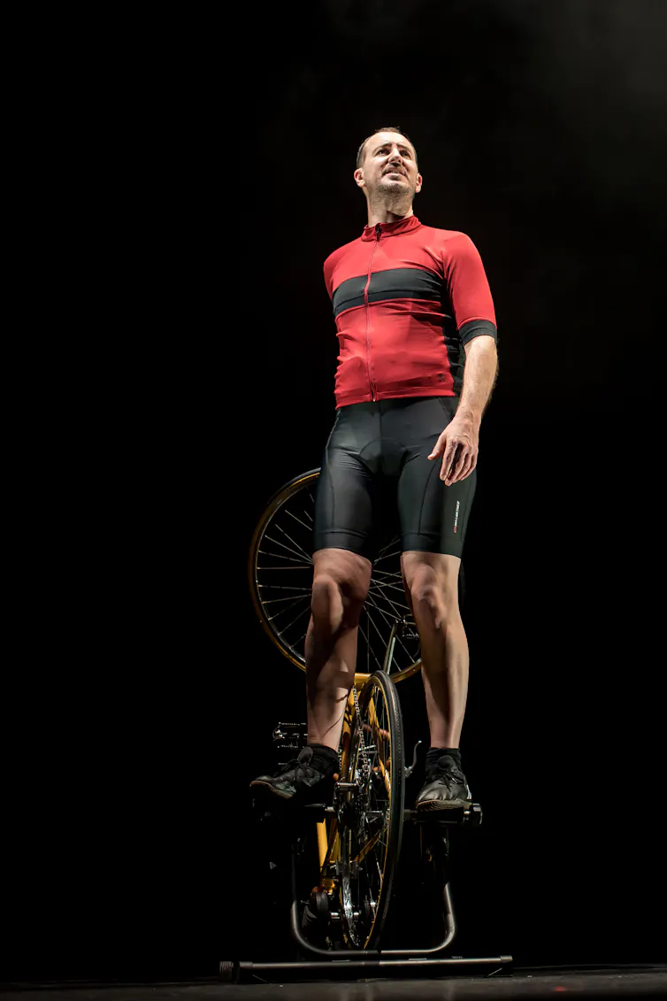 A man stands on a bike
