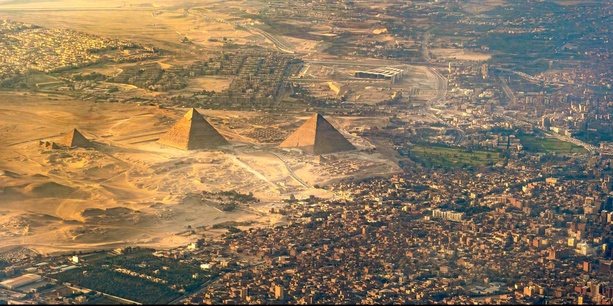 Aerial photo of pyramids with city nearby