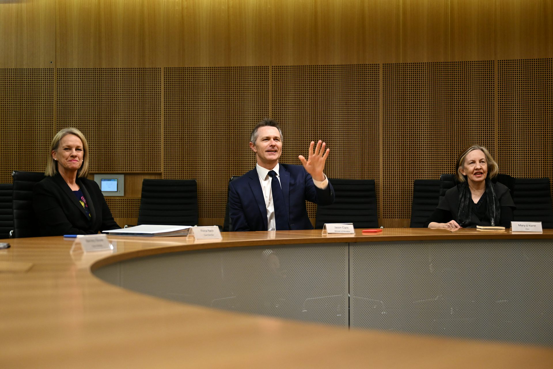 Education Minister Jason Clare and Professor Mary O'Kane sit at a conference table.