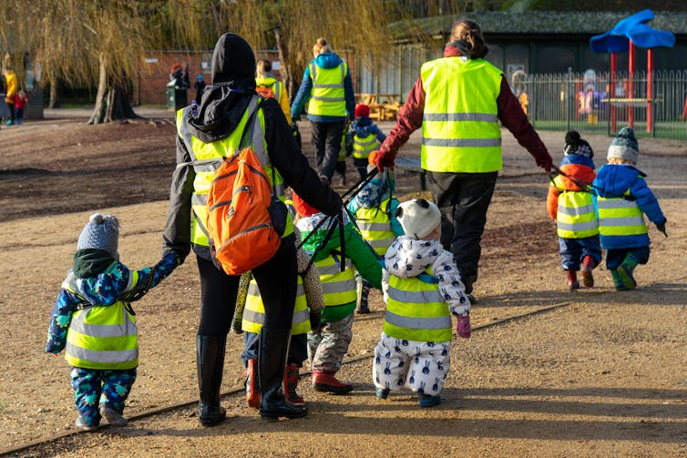 A group of nursery children walking with staff