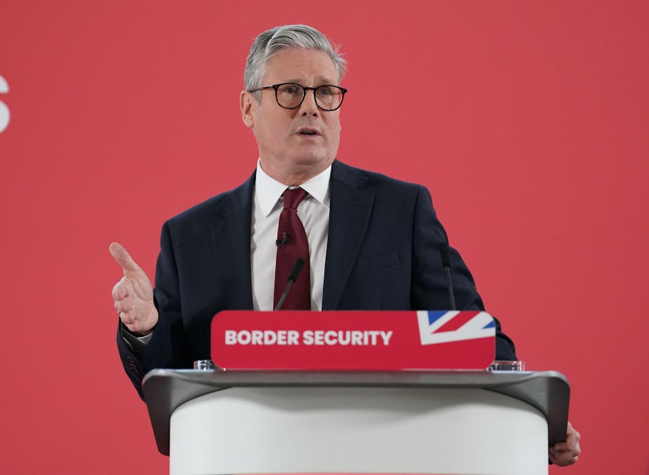 Keir Starmer speaking at a podium that has a red placard reading 'border security'