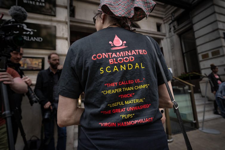 Protester wearing a t-shirt listing deregoratory terms used to describe contaminated blood victims
