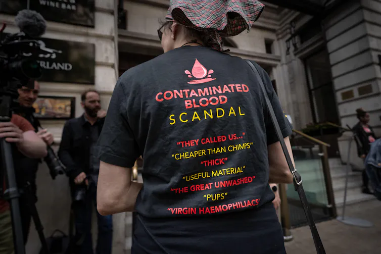 Protester wearing a t-shirt listing deregoratory terms used to describe contaminated blood victims