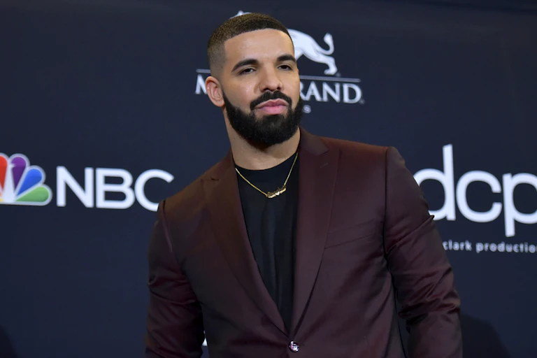 A Black man in a suit poses for a photo