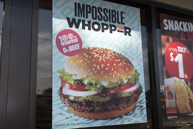 An ad says 'Impossible Whopper' and has a photo of a burger on a bun with lettuce, tomato and onion.