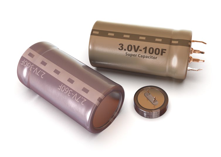 Two metallic supercapacitors, which are cylinders with metal prongs at one end.