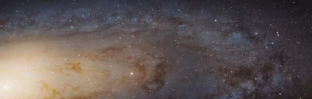 a photo of the sky with a bright spot in the lower left corner and navy blue background with white spots