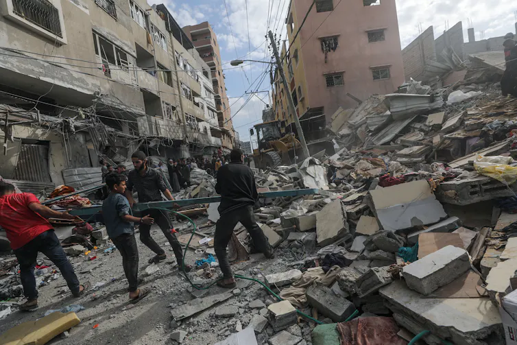 People searching under the debris of a damaged building.