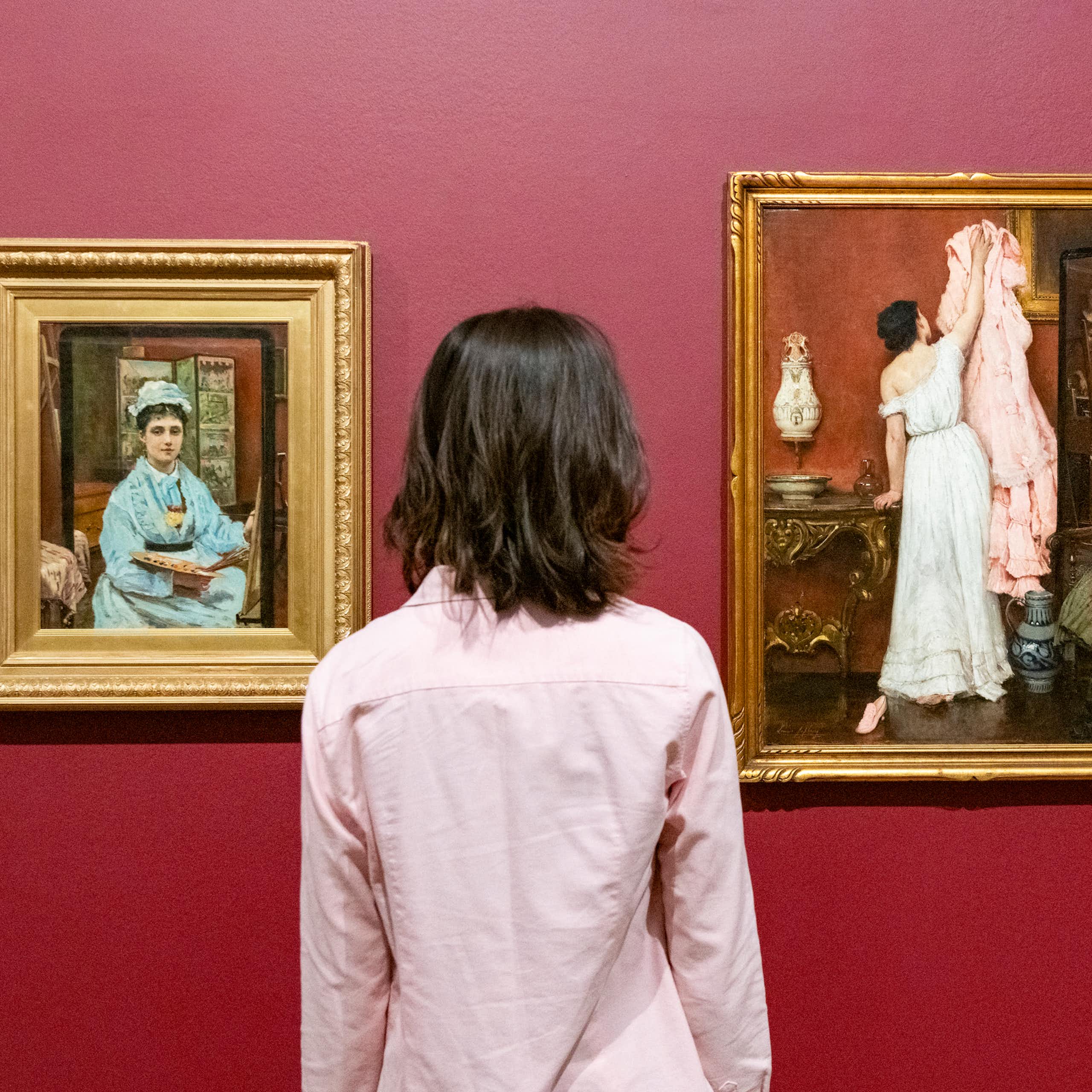 Woman looking at two paintings. 