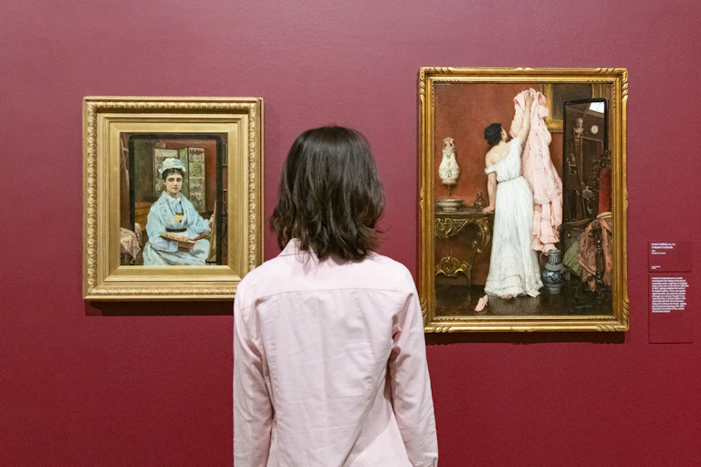 Woman looking at two paintings.
