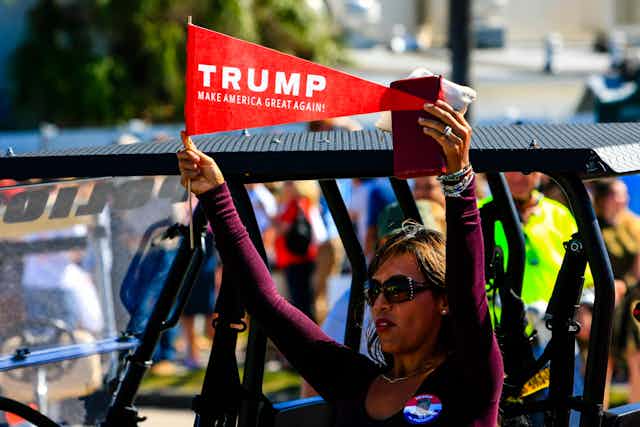 A woman hold a pro-Trump pennant.