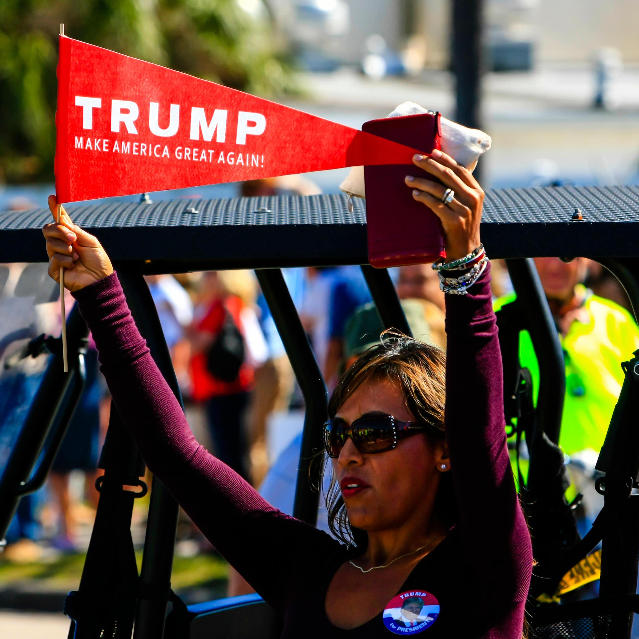 A woman hold a pro-Trump pennant.