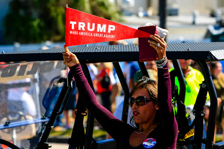 A woman hold a pro-Trump pennant.