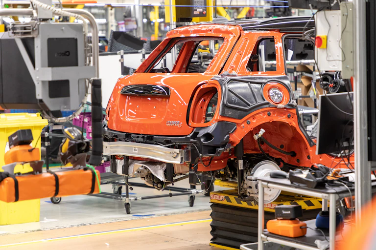 An orange Mini on the factory floor.