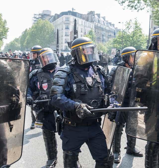 Des policiers français dégagent les manifestants de la chaussée lors d'une  manifestation du 1er mai à Paris.
