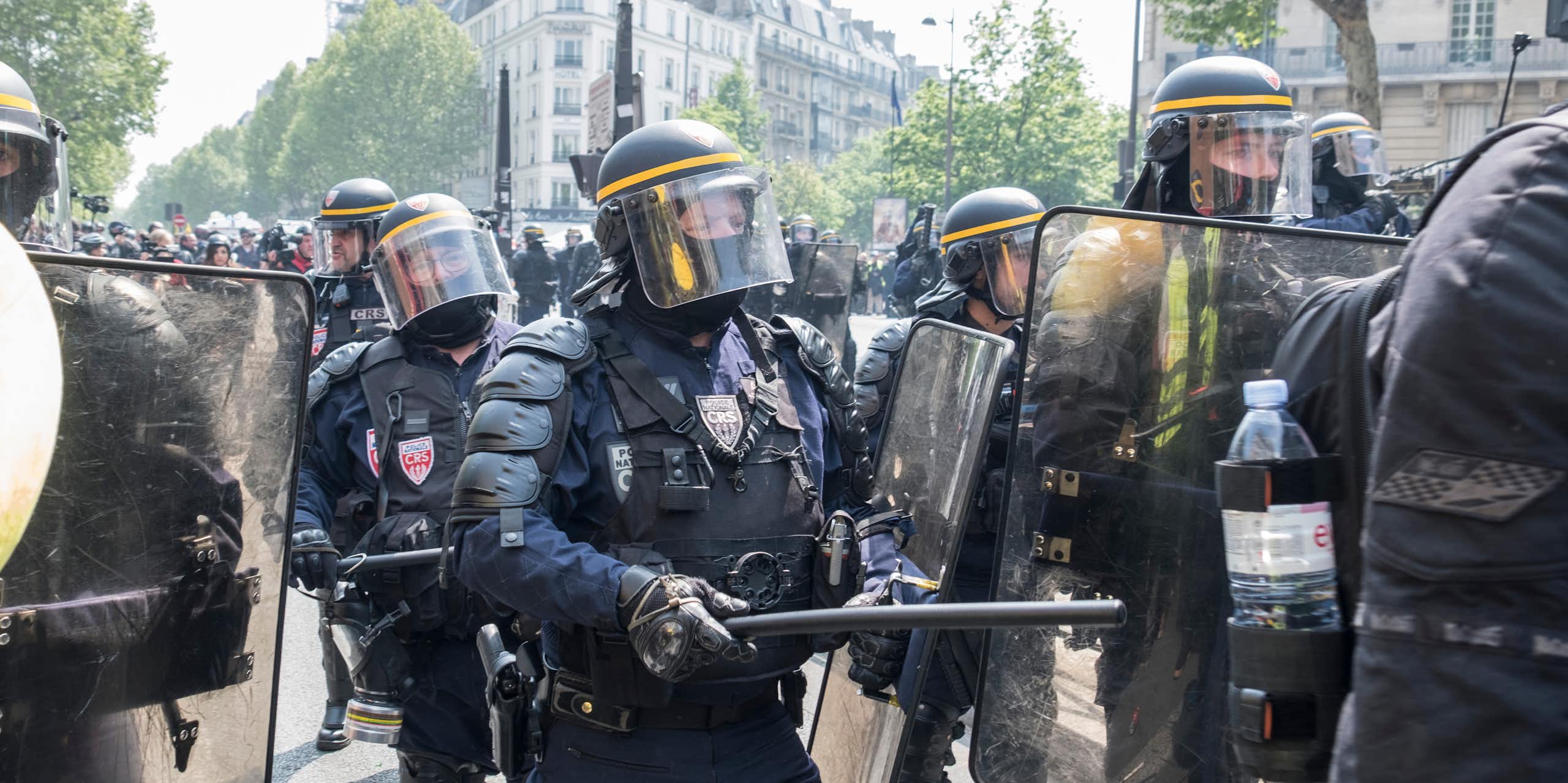 Des policiers français dégagent les manifestants de la chaussée lors d'une  manifestation du 1er mai à Paris.