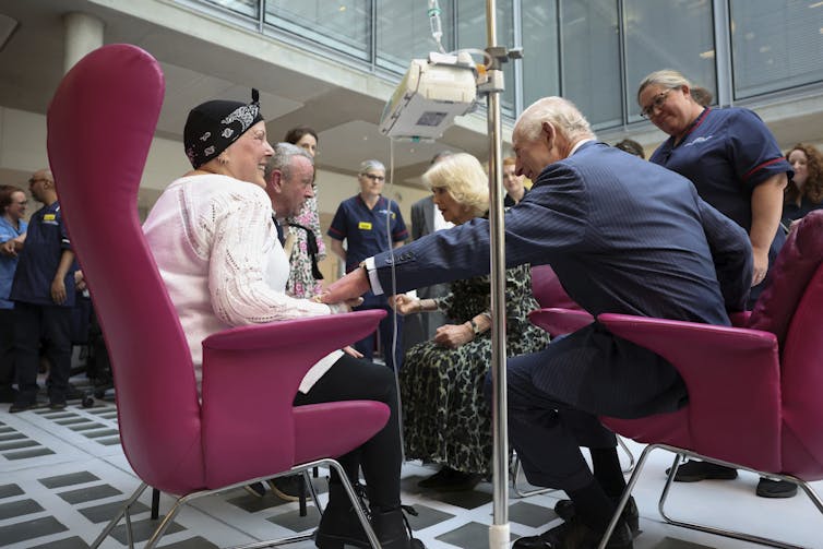 Elderly people sit in chairs.