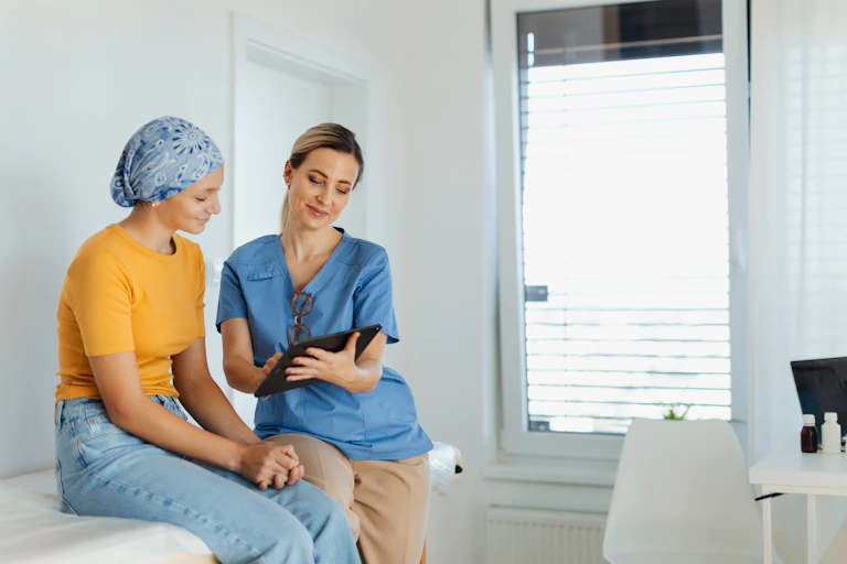 A patient and a doctor sit on a table.